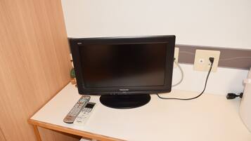 Un televisor sobre una mesa blanca con un control remoto.