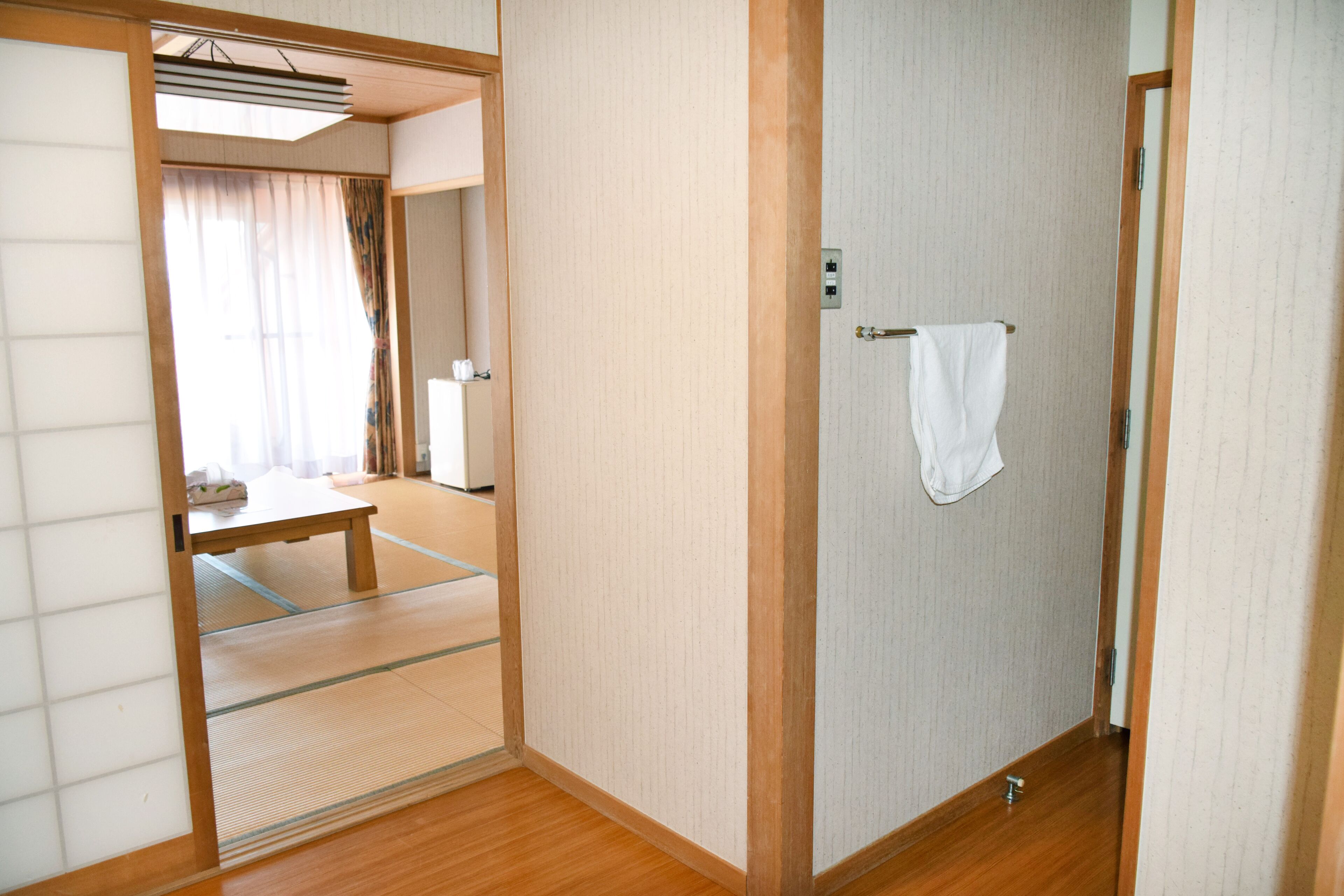 A traditional Japanese room with tatami flooring, a shoji screen door, and a small wooden table.