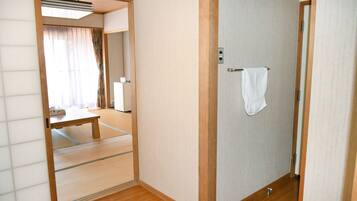 A traditional Japanese room with tatami flooring, a shoji screen door, and a small wooden table.