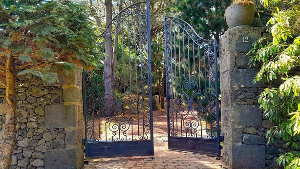 A stone pathway leading to a wrought iron gate with a number '12' on a stone pillar. - Guest House with excellent way for walking, explore neighbor villages or bicycle (Fenais da Luz)