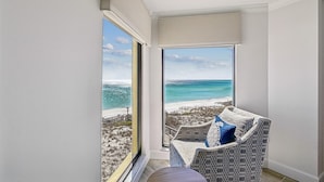 A balcony with a view of a beach and ocean.