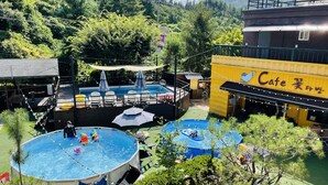 Un área de piscina con varias piscinas, un escenario y un café.