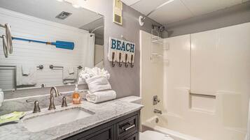 Kylpyhuone, jossa on marmorinen pesuallas, wc, suihku ja pyyheteline pyyhkeineen.