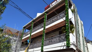 A multi-story building with balconies adorned with greenery. - Hotel Swagat (Abu Road)