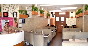 A restaurant with booths and a reception area. - Hotel Swagat (Abu Road)