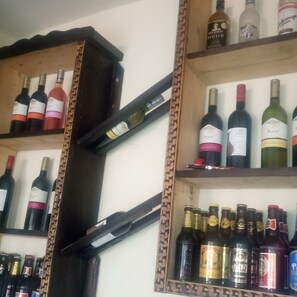 Uma estante com diversos vinhos.
