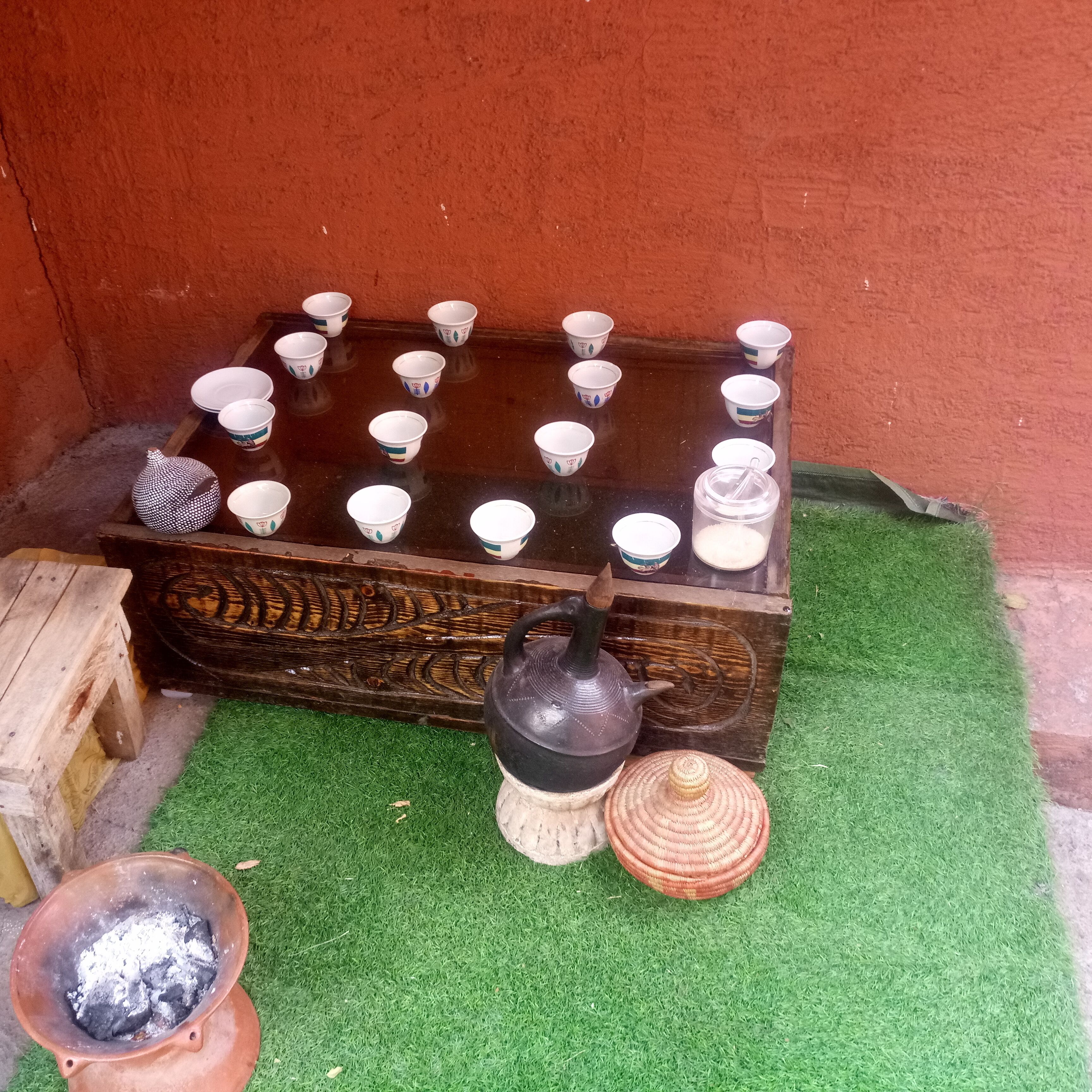 A traditional tea set with multiple cups and a teapot on a wooden table.
