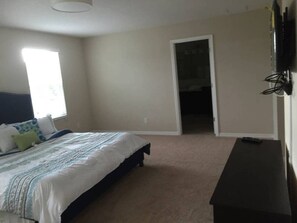 A bedroom with a bed, a dresser, a door leading to another room, and a window. - 10 Beds! Modern House. Universal & Convention (Orlando)