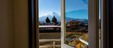 A view from a balcony with a mountain in the background.