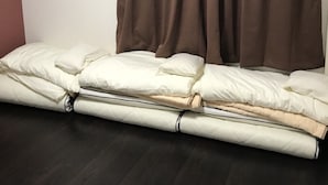 A room with a bed, brown curtains, and a white wall. - SoraTerrace (Nishitokyo)