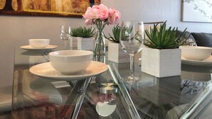 A dining table set with white bowls, wine glasses, and potted plants. - Tideview 20 · Walk TO Convention! Near Universal & Disney (Orlando)