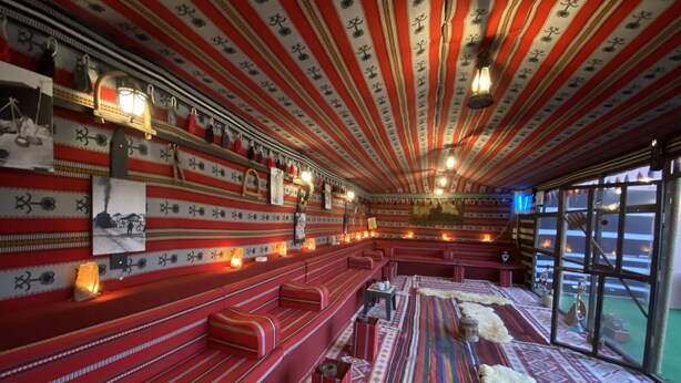 A room with red benches, patterned walls, and a fur rug. - Petra Aretas Hotel (Wadi Musa)