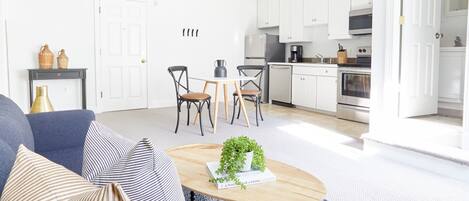 Ein modernes Wohnzimmer mit einer Couch, einem Couchtisch und einem Essbereich mit Stühlen.