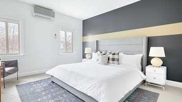 A modern hotel room with a large bed, bedside tables, and a desk.