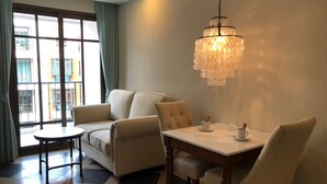 Un salon moderne avec un canapé, une table ronde et un lustre.