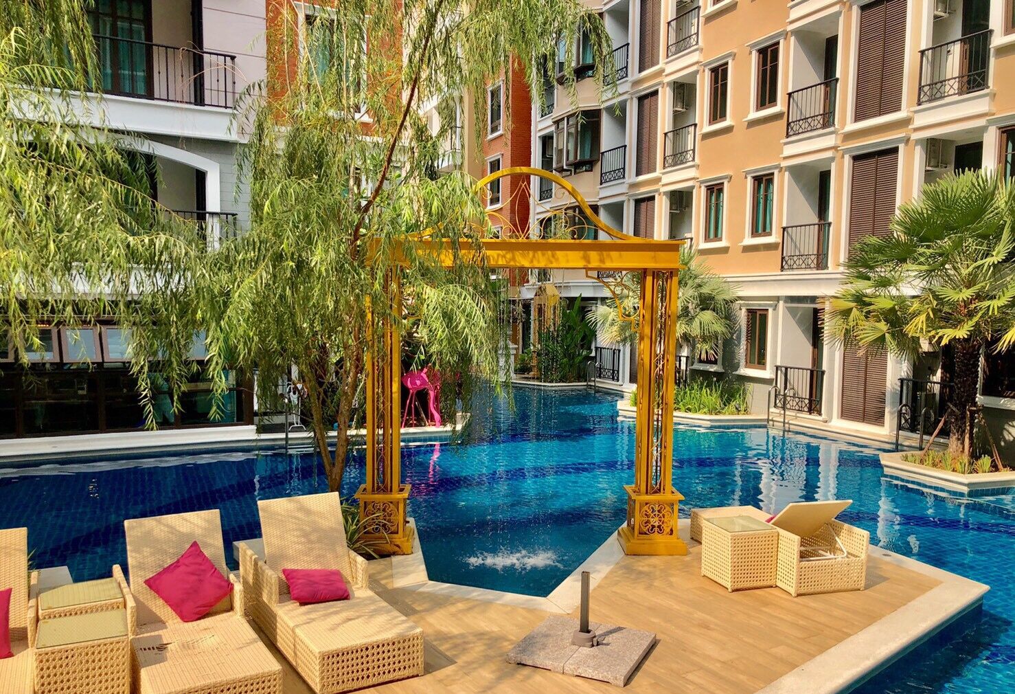 An indoor swimming pool with lounge chairs and a pergola structure.