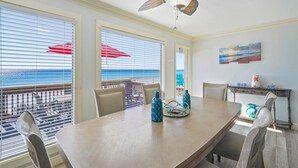 A dining area with a large table, chairs, and a ceiling fan. - Beautiful Beachfront 4BR Green Reef townhome with Ocean Views! (Destin)