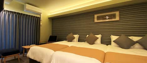 A hotel room with a large bed, a desk, and a chair.