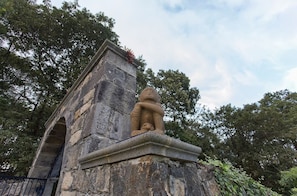 Eine Steinstruktur mit einer Statue, umgeben von Bäumen.