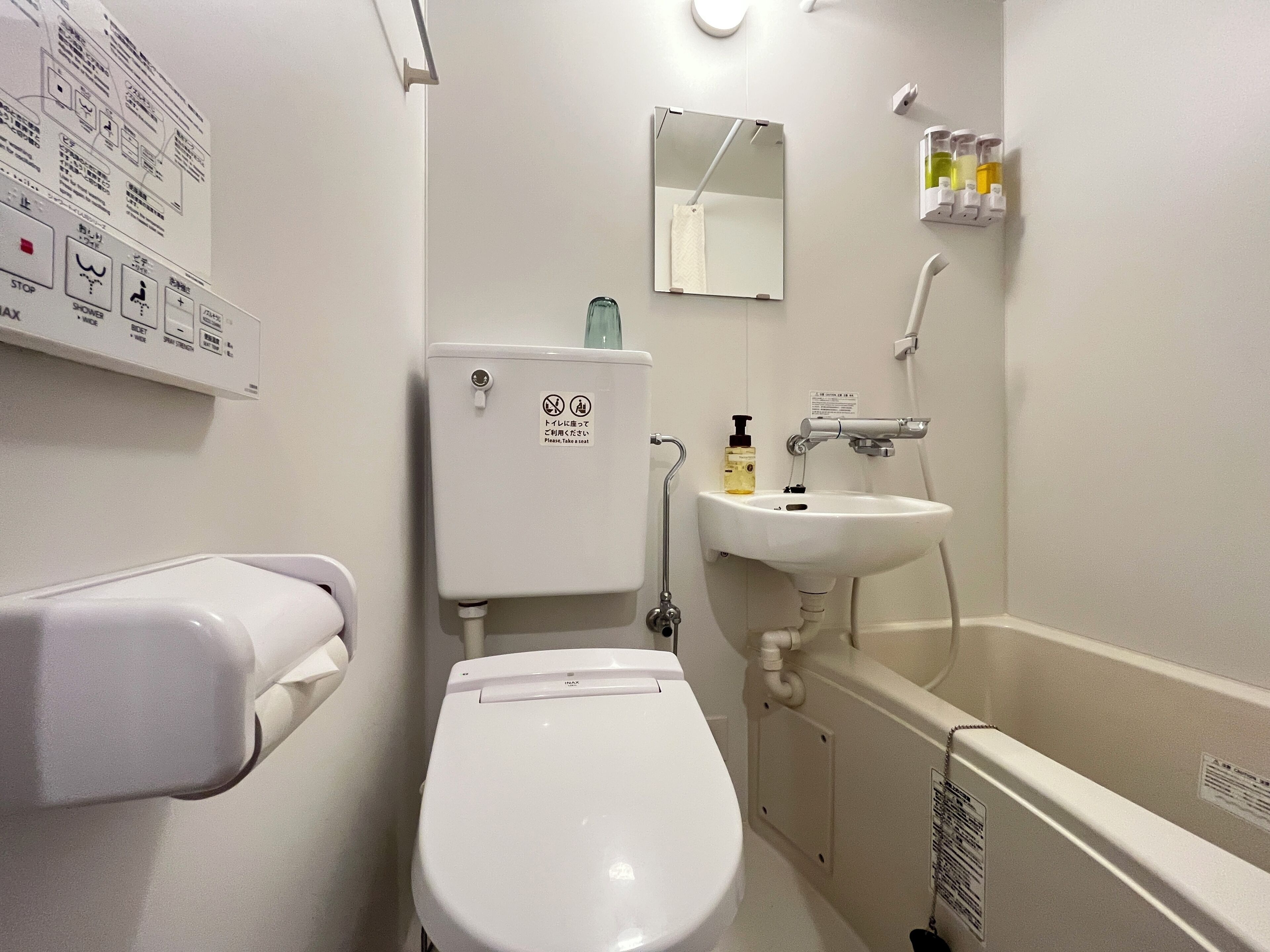 A standard hotel bathroom with a toilet, sink, and hand dryer.