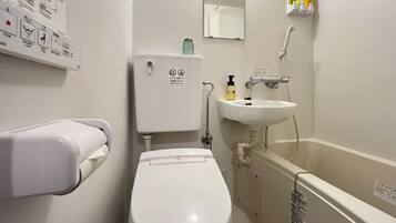 A standard hotel bathroom with a toilet, sink, and hand dryer.