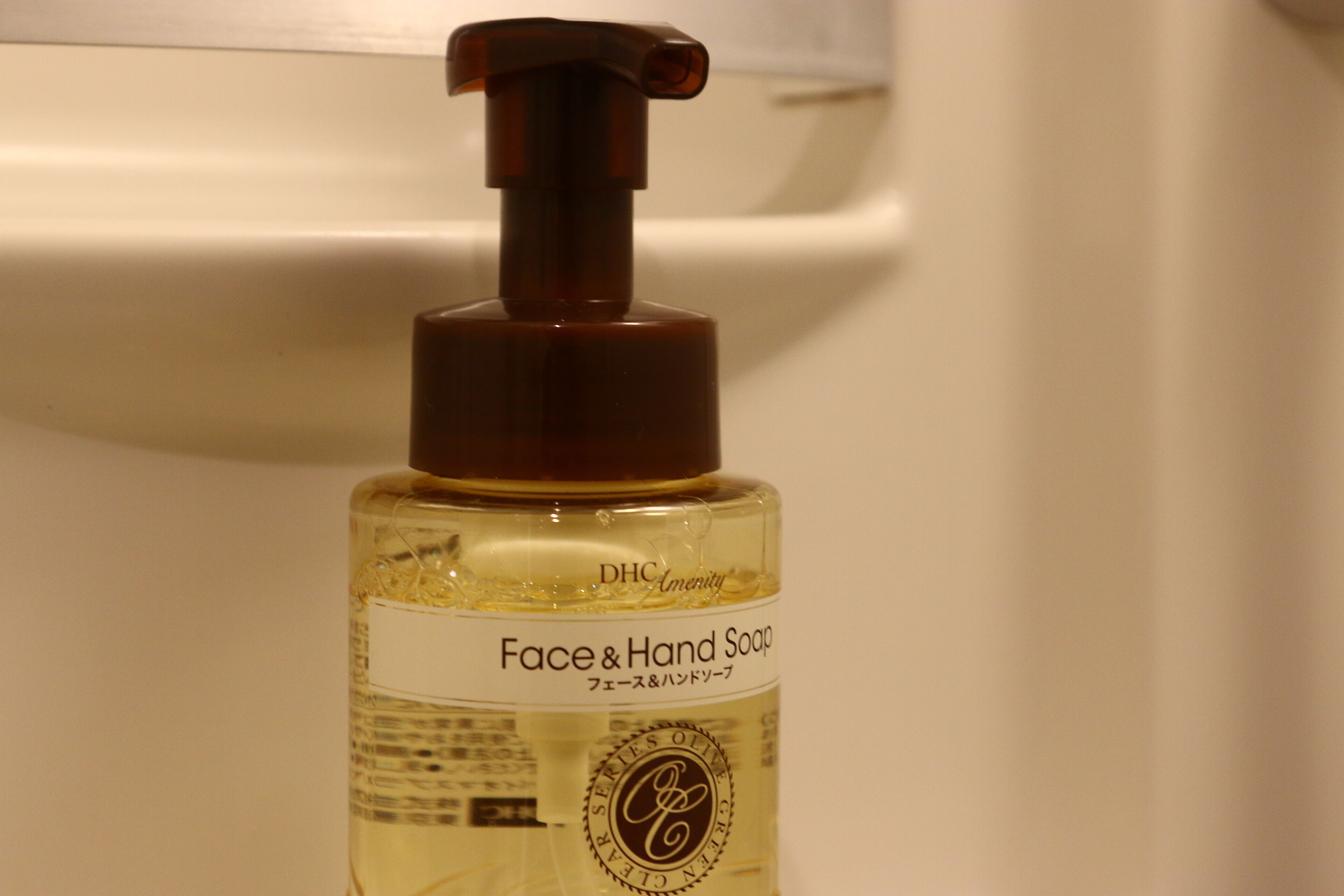 A bottle of face and hand soap with a pump dispenser.