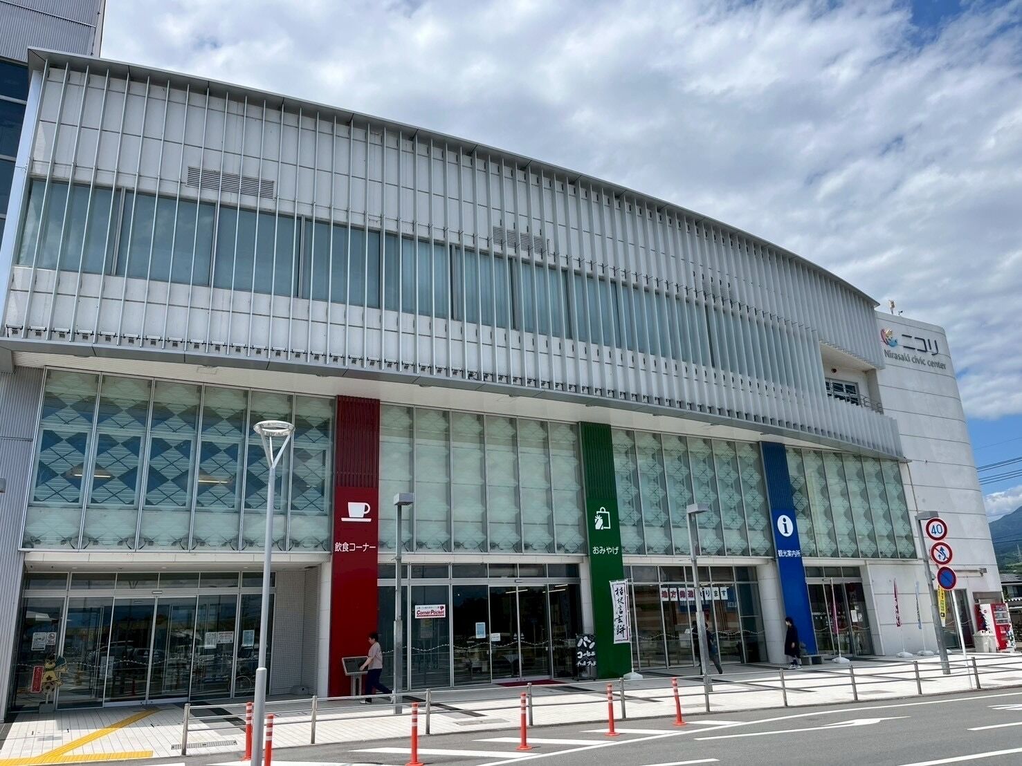 A modern building with large glass windows and a curved facade.