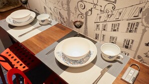 A dining table set with white plates, blue and white cups, and a metal spoon. - FC House Shibuya 101 (Tokyo)