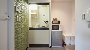 A compact kitchen with a microwave, refrigerator, and a sink. - FC House Shibuya 202 (Tokyo)