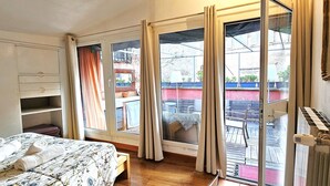 A bedroom with a bed, a wardrobe, a radiator, and a view of the outside balcony. - Navona Loft Terrace, splendid apartment with terrace in the historic center (Roma)