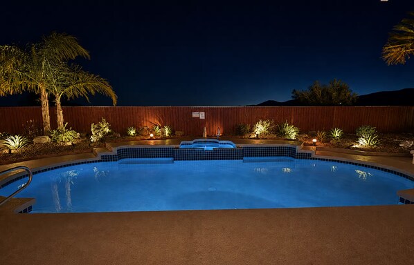 Una piscina con muelle de madera y palmeras.