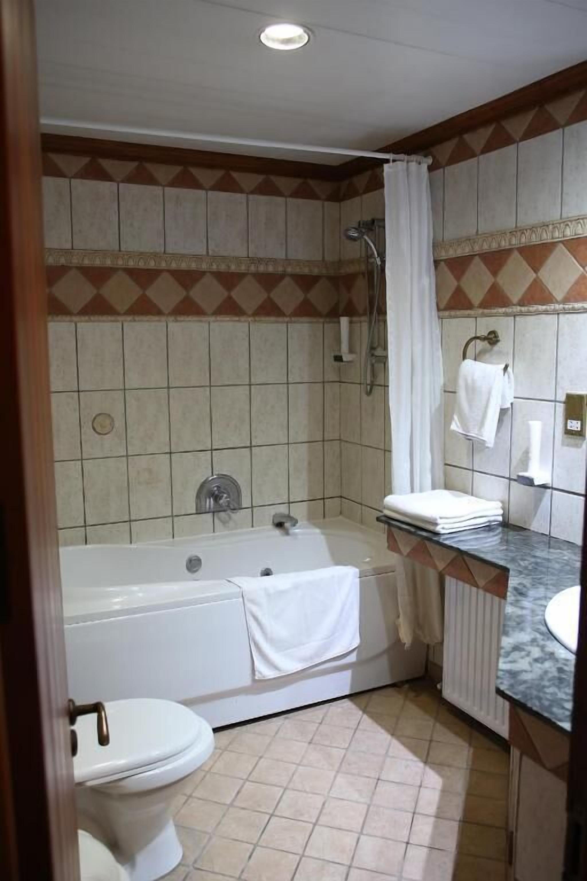 Un baño con bañera, inodoro y lavamanos.