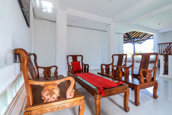 A room with a wooden sofa set, a red runner, and a wooden coffee table.