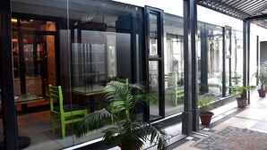 En moderne bygning med store glasvinduer, en grøn stol og potteplanter.