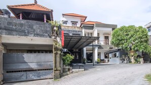 A residential area with a paved driveway, a covered entrance, and a stone wall.