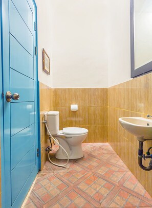 A bathroom with a toilet, sink, and blue door. - OYO 2544 Just-in Hotel (Mataram)