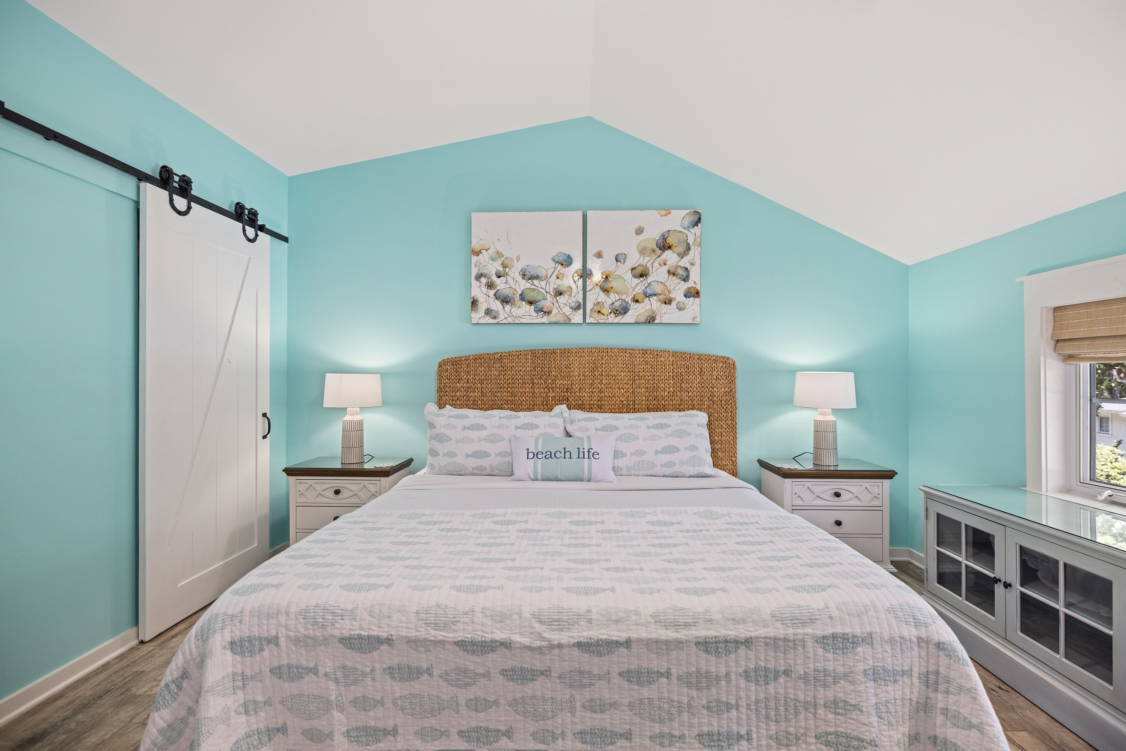 Quarto com cama, duas mesas de cabeceira, janela e guarda-roupa.