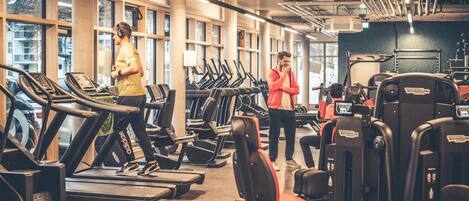 A gym with treadmills, weight machines, and benches.