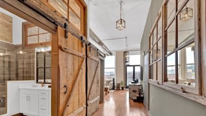 Cocina amplia con armarios de madera, un gran puerta corredera estilo granero y vistas de la ciudad a través de amplios ventanales.
