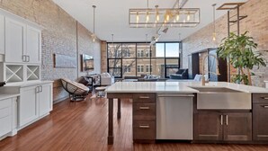 Una cocina moderna con una isla central, armarios de madera y un ventanal que ofrece vistas de la ciudad.