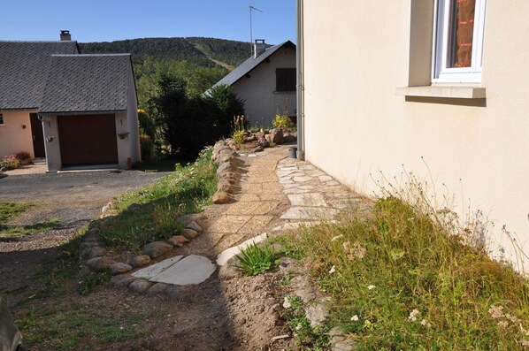 Un chemin de pierres menant à une maison avec un garage et une fenêtre.