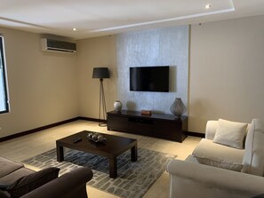 Deluxe Apartment | Living room | 40-inch LCD TV with satellite channels, TV, streaming services - Euneva Court Townhouses - Bentley Place (Accra)