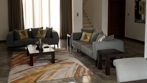 A modern living room with a sofa set, a coffee table, and a rug.