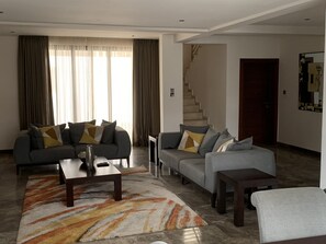 Signature Townhome | Living area | 40-inch LCD TV with satellite channels, TV, streaming services - Euneva Court Townhouses - Bentley Place (Accra)