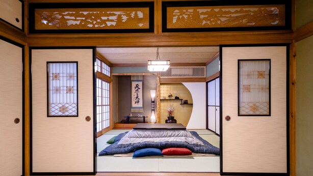 A traditional Japanese room with tatami flooring, shoji screens, and a futon bed with pillows. - ID STAY Kawaguchiko 3 (Fujikawaguchiko)