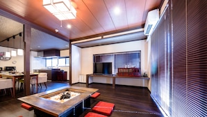 A modern living room with a wooden coffee table, red cushions, and a TV. - ID STAY Kawaguchiko 3 (Fujikawaguchiko)