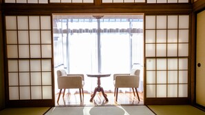 A traditional Japanese room with tatami flooring, a shoji screen, and a low wooden table with two chairs. - ID STAY Kawaguchiko 3 (Fujikawaguchiko)