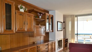 A spacious room with wooden cabinetry, a large bed, and a balcony with a view. - Sant Telm A - Calafell (Calafell)