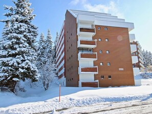 A multi-story building with a brick facade, balconies, and a sign indicating "LE CLARET". - Renovated Studio 3/4 pers near slopes Chamrousse (Chamrousse)
