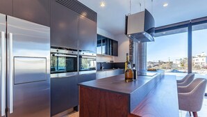 Una cocina moderna con electrodomésticos de acero inoxidable, una isla grande y vistas a la ciudad.